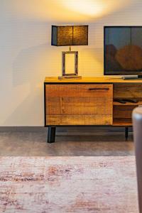 a wooden dresser with a television on top of it at Le 28 C chouette - Spacieux - Box privé - Ascenseur - Centre in Dijon