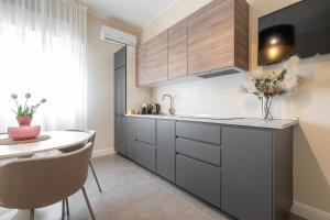 a kitchen with grey cabinets and a white table at Corner Apartment via Italia in Quartu SantʼElena +13 photos