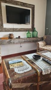 a living room with a table and a tv on a wall at Casa Eike in El Calafate +13 photos