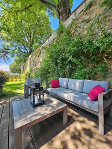 a couch and a table on a wooden deck at La Bâtie - Vue imprenable - Amazing view - Parking privé in Vienne