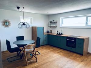 a kitchen with a table and a table and chairs at Tolle Wohnung mit Seeblick in Zell am Moos