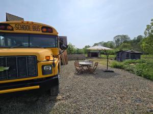 BassengeにあるSchool busの傘が置かれたテーブルの隣に停まっているスクールバス