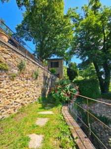 a stone wall with flowers and a fence at La Bâtie - Vue imprenable - Amazing view - Parking privé in Vienne