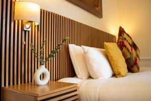 a hotel room with a bed with a vase on a table at The Scole Hotel in Scole