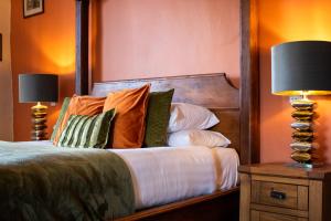 a bedroom with a bed with pillows and two lamps at The Scole Hotel in Scole