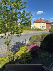 a garden with a fence and flowers on a street at FeWo Böhmeheide Soltau in Soltau