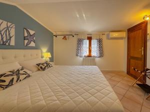 a bedroom with a large white bed and a window at 49 Sea Rooms - Guesthouse by Host Hero in Stintino
