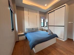 a bedroom with a large bed and a large window at The Lake Huay Yai Three-Bedroom Villa in Ban Huai Yai