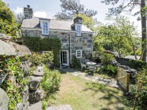 an old stone house with a garden in front of it at Pen Y Bryn Bach in Harlech