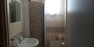 a small bathroom with a sink and a mirror at Il Sole del Mediterraneo in Noto +82 photos