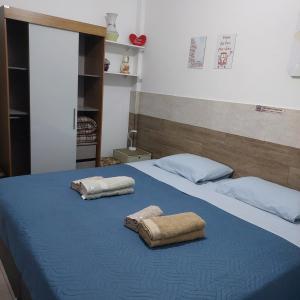 a bed with two towels on top of it at Bonito é ser Feliz in Recife
