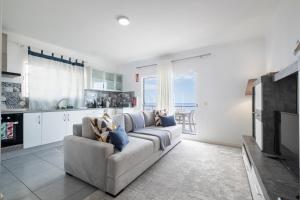 Una sala de estar con un sofá y una cocina. en Esterinha's Ocean Apartment by GALMI, en Jardim do Mar