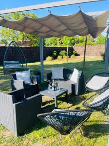 patio z krzesłami i stołem pod baldachimem w obiekcie LA DEMEURE DU CERF - gîte de charme privatif en Sologne 6P avec Jacuzzi et piscine chauffée - Lamotte Beuvron Zoo de Beauval Center parcs w mieście Chaon