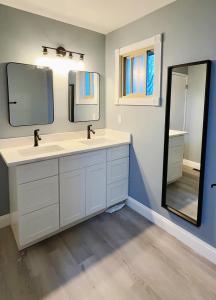 a bathroom with two sinks and a large mirror at Gorgeous House&30 second Bus station Close C-Train& Free Parking in Calgary