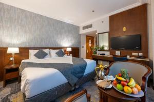 a hotel room with a bed and a bowl of fruit at Nozol Royal Hotel in Medina