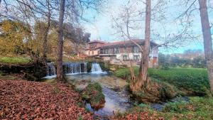 einem Wasserfall vor einem Haus neben einem Fluss in der Unterkunft Villa vacacional el Castañin in Pancar