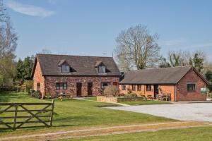 a large brick house with a black roof at Zoe's Cottage with Alpaca's and 7 mins drive to Alton Towers in Denstone