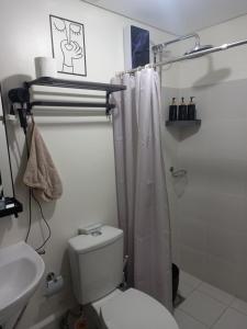 a bathroom with a toilet and a shower curtain at Spacious Staycation in Pasig Urban Metro Escape in Manila