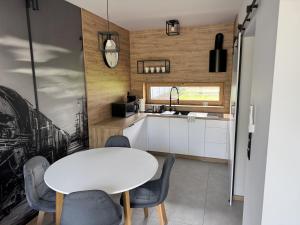 a kitchen and dining room with a white table and chairs at Domki przy Parowozowni in Wolsztyn