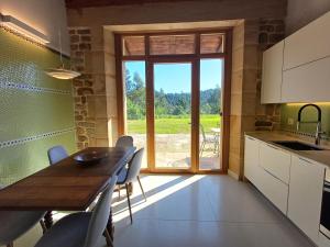 a kitchen with a table and chairs and a large window at Apartamento en casa de campo Villa Haritza con vistas al mar in Ea
