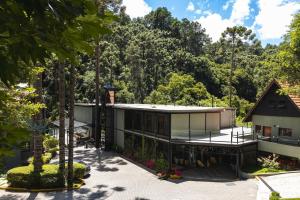 an exterior view of a house with trees at I am Boutique Hotel Campos do Jordão by Unna in Campos do Jordão