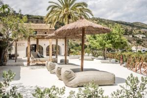 een rij ligstoelen onder een paraplu bij Finca de los Secretos in Benissa