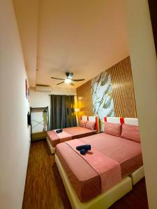a bedroom with two beds and a ceiling fan at K avenue by TZ homestay in Donggongon