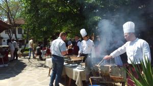 a group of chefs cooking food on a grill at Bozukova House in Sliven