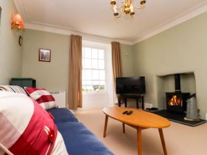 a living room with a blue couch and a table at Flat 3 in Holyhead