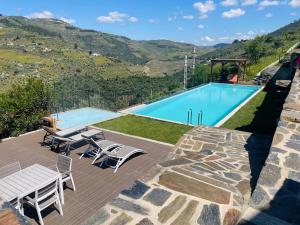 a swimming pool with a picnic table and chairs next to a patio at Quinta do Casal Bystol, Casa 1 in Casal de Loivos