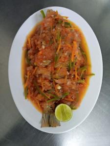 a plate of food with a bowl of soup with a lime at Kareem Zanzibar in Zanzibar City