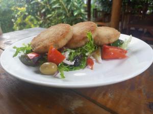 a white plate with food on a wooden table at Kareem Zanzibar in Zanzibar City