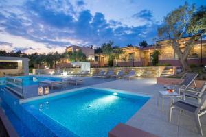a swimming pool with chairs and a house at Aventura Village in Potos