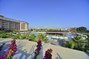 vistas a la piscina de un complejo con flores púrpuras en Sunmelia Beach Resort Hotel & Spa-All Inclusive, en Kizilagac