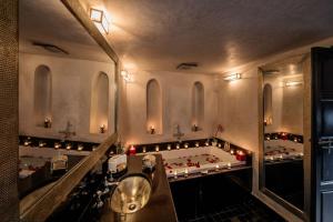 a bathroom with a tub and a large mirror at Riad Star by Marrakech Riad in Marrakech