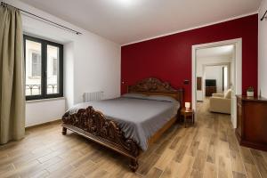 una camera da letto con un letto e una parete rossa di Casa Antonelli a Ghemme
