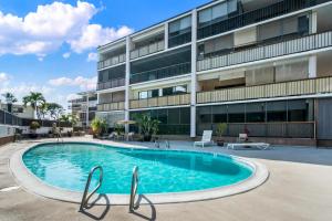 a swimming pool in front of a building at Big Island Kona Plaza 220 by Coldwell Banker Island Vacations in Kailua-Kona