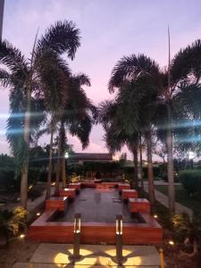 a park with benches and palm trees at dusk at Urban Metro Escape in Pasig City in Manila