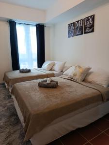 two large beds in a room with two large windows at Urban Metro Escape in Pasig City in Manila