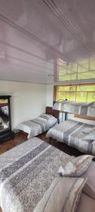 a group of beds in a room with a window at Finca San Jerónimo in Arbeláez +63 photos