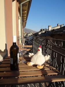 a bottle of wine and a stuffed animal sitting on a table at Maison Soleil - Mansarda in Aosta
