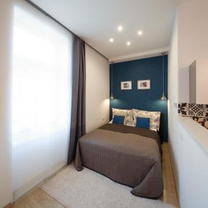 - une chambre avec un lit et un mur bleu dans l'établissement STUDIO 16, à Sopron