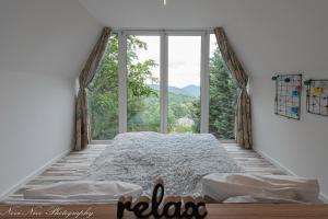 a bedroom with a bed and a large window at Altitude Matra in Mátraszentimre