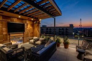a balcony with a tv and a couch and chairs at The Bell Athens by Kasa in Athens +42 photos