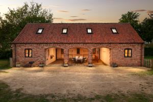 a brick house with a red roof at Hilltop Farm Holidays in Lincoln