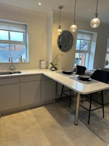 サニングデールにあるLuxury contemporary Apartmentのテーブルと壁に時計があるキッチン