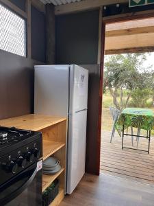 a kitchen with a white refrigerator and a stove at The Termite Mound - Termite Tented in Khwai