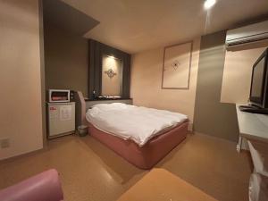 a small room with a bed and a microwave at 佐渡ホテル Hotel NestTime in Sado +28 photos