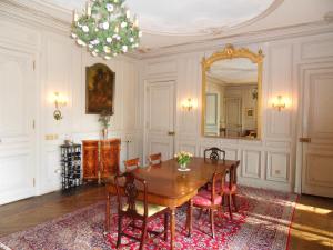 a dining room with a table and a mirror at Château de la Motte in Noailly