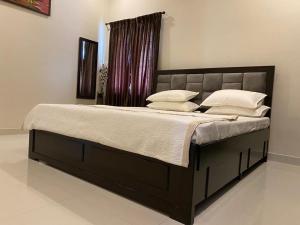 un lit avec des oreillers blancs dessus dans une chambre dans l'établissement LBS Farmstay, à Alāndurai